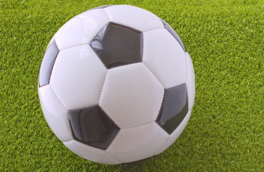 A White and black football over grass 