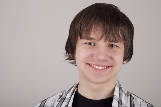 portrait of teen boy, gray background gray