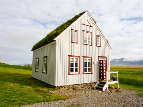 Icelandic traditional alone turf roof house in countryside