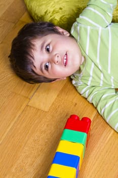 Caucasian baby in green shirt playing with bright colorful abacus
