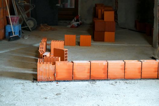 first hollow brick row of a wall on construction site