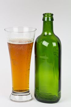 A glass of Beerand an empty bottle