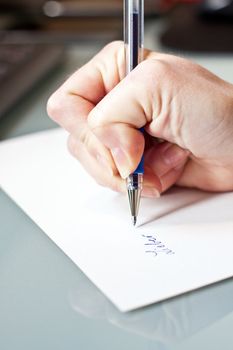 womans hand is writing a letter with a pen 