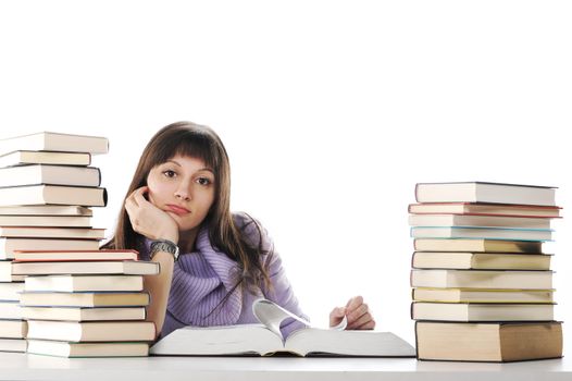 Tired of studies, A beautiful young woman sitting at a desk with two large piles of books.