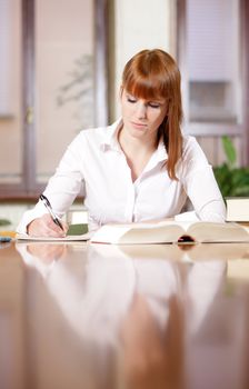 Young student doing her homework at a table 