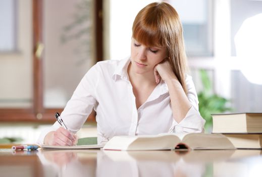 Young student doing her homework at a table