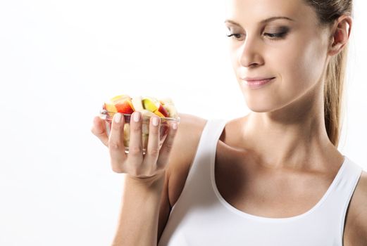 Fit young woman eating fruit salad