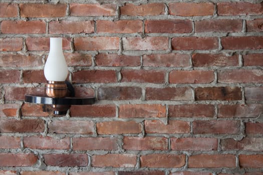 Old-fashioned sconce light on a brick wall.