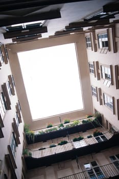 Looking upward from a central courtyard inside an apartment complex in european city