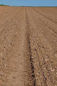 Closeup on ploughed field with horizon in early spring