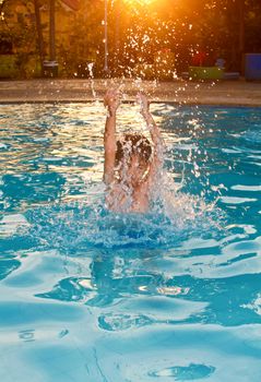 Boy splashing water in a private pool full of enjoyment.