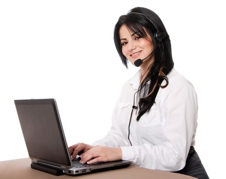 Beautiful happy customer service representative at call center office desk with headset and laptop computer online chatting, isolated.