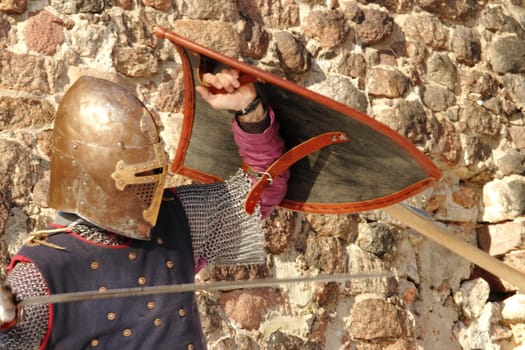 warlike knight in armor against the fortress wall