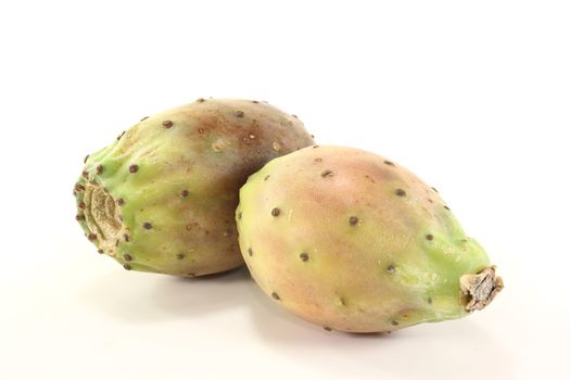 two fresh red and green prickly pears on a bright background