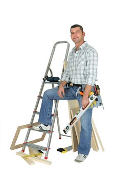 Carpenter stood with ladder and spirit-level