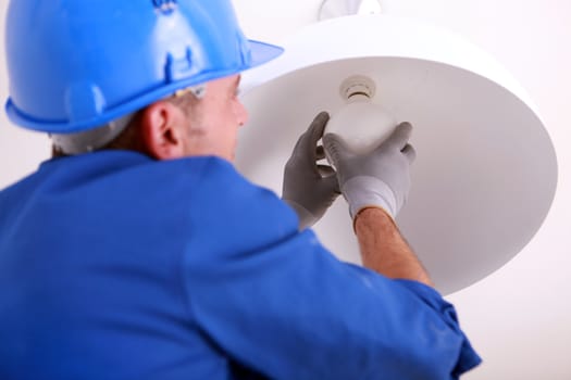 Electrician installing new light bulb