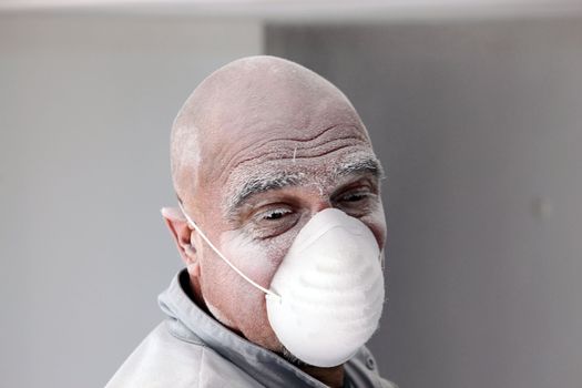 Bald plasterer covered in dust