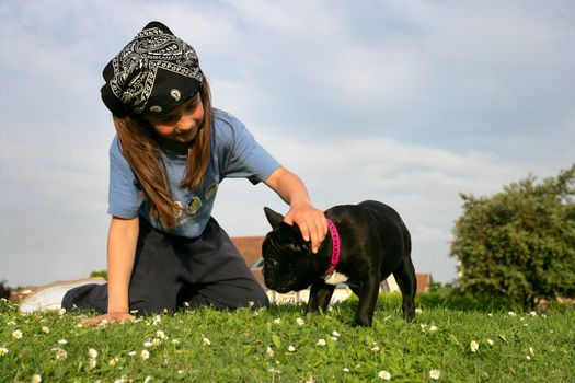 Child playing with her dog on a lawn