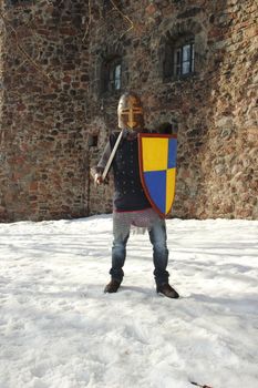 warlike knight in armor against the fortress wall