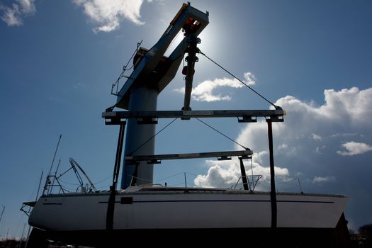  Sailboat lift up by a heavy industrial boat lifter for maintenance                             