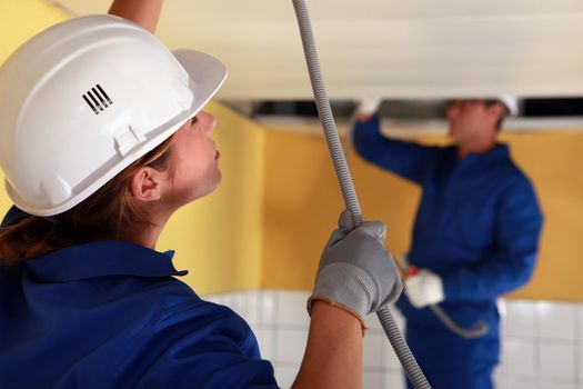 Electricians wiring a large room