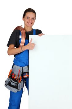 Female plumber with a board left blank for your message