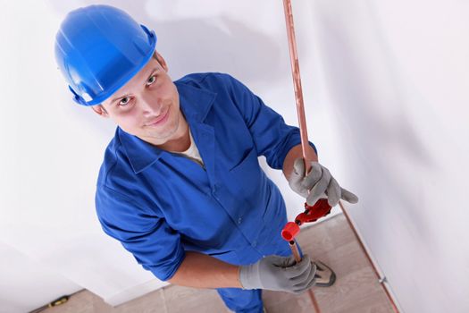 Smiling laborer installing piping