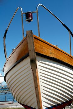 Details of the front part of a prow of a wooden yacht boat  with clear blue sky background    