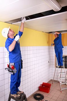 Electricians in room under construction