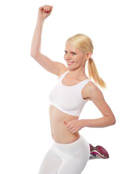 Beautiful athlete jumping with one hand up wearing sports outfit