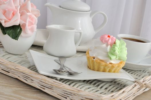 Cake on a saucer with a cup of coffee on a tray
