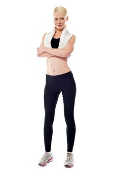 Smiling sports woman standing with folded arms isolated over white background