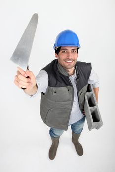 Bricklayer with trowel and cement block