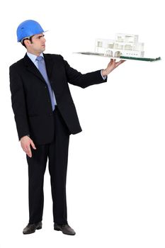 architect in suit holding model looking annoyed