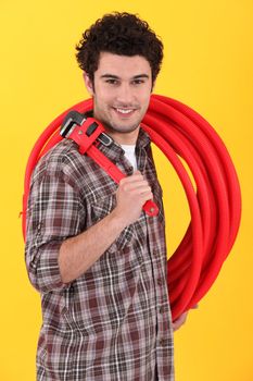Plumber holding wrench and length of plastic pipe