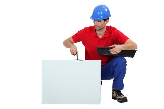 Bricklayer cementing a board left blank for your message