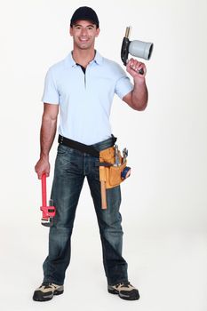 A plumber holding a wielding torch and a wrench.