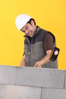 Worker hitting a wall with a sledgehammer