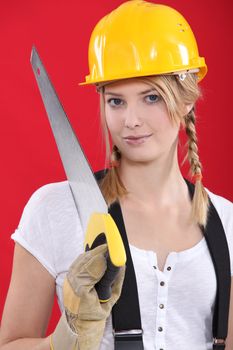 Woman with a hardhat and handsaw