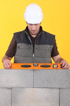Construction worker measuring an angle with a spirit level
