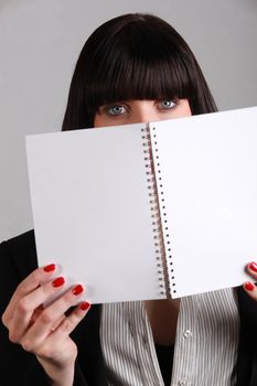 woman hiding behind wire-bound notebook