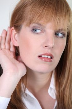 Woman listening with her hand behind the ear