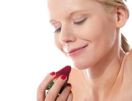 Attractive young lady holding a strawberry, about to eat