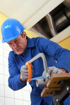 Man sawing a pipe.