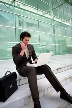 Businessman sat on steps working