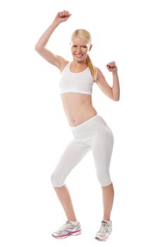 Cheerful sporty fit girl in sporty outfit posing in front of camera