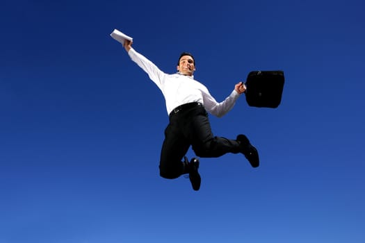 Successful businessman jumping in the air