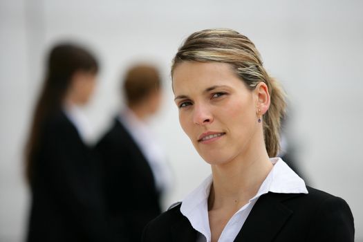 Blond woman stood with colleagues in background