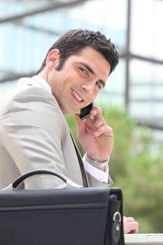 Businessman using a cellphone outside
