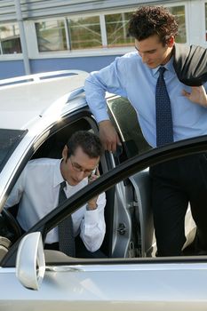 Businessmen by a car
